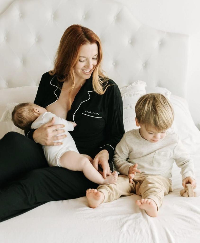 mama nursing baby in bed with toddler
